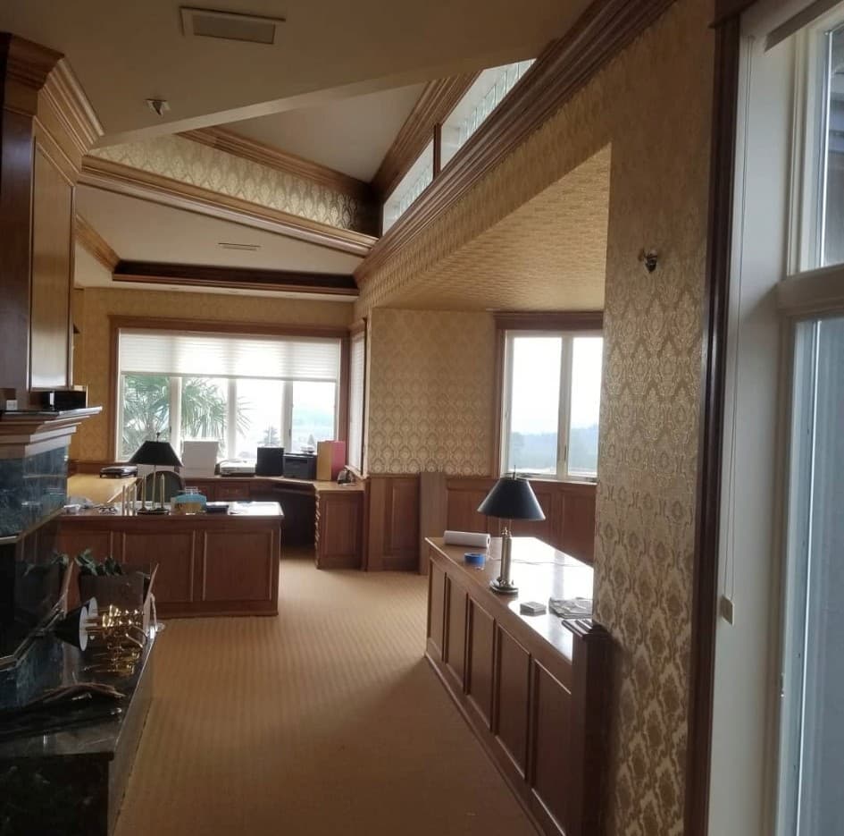 Spacious home office with cream and gold damask wallpaper and panoramic windows
