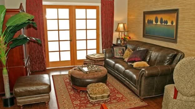 Residential living room with grasscloth wallpaper and leather sofa featured on Extreme Makeover Home Edition TV show